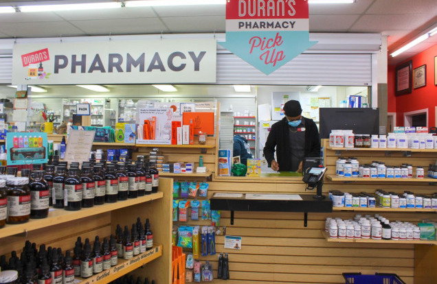 smiling pharmacist helps customer